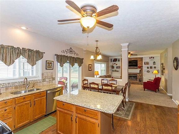 Kitchen. Spectacular kitchen opens to family room with incredible updates including: Oversized GRANITE breakfast island + counters, stunning tile backsplash, gorgeous hardwoods and newer SS appliances!