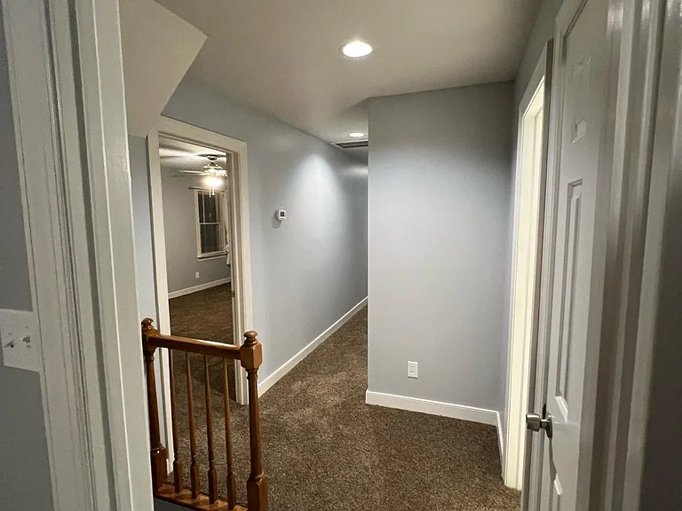 Photo leaving the master bedroom looking into the hallway, staircase and bedroom 1 on the left