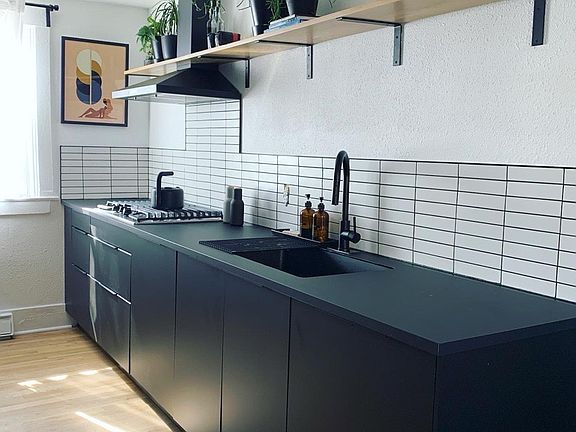 Open shelving, large undermount sink, integrated trash bins and plenty of countertop space