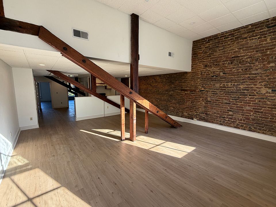 Open plan, loft-style space with historic exposed brick and structural elements.