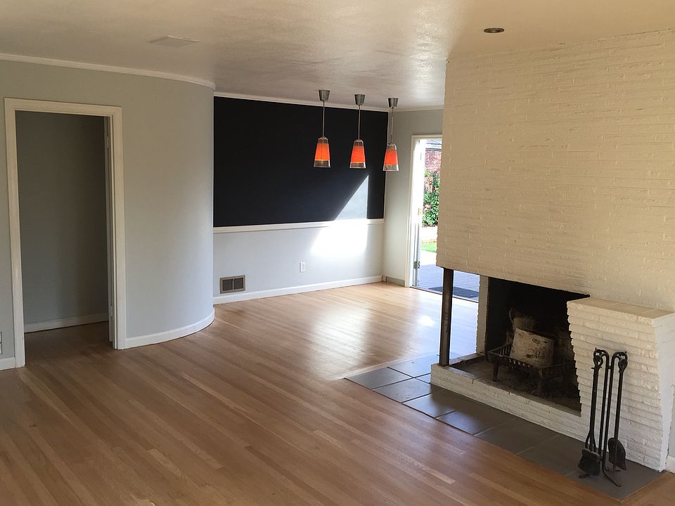 Coverphoto - Looking from living area at doorway to bedrooms, fireplace, dining area, and French doors to backyard