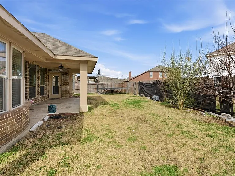 Fenced backyard with a trampoline, a patio, and a ceiling fan