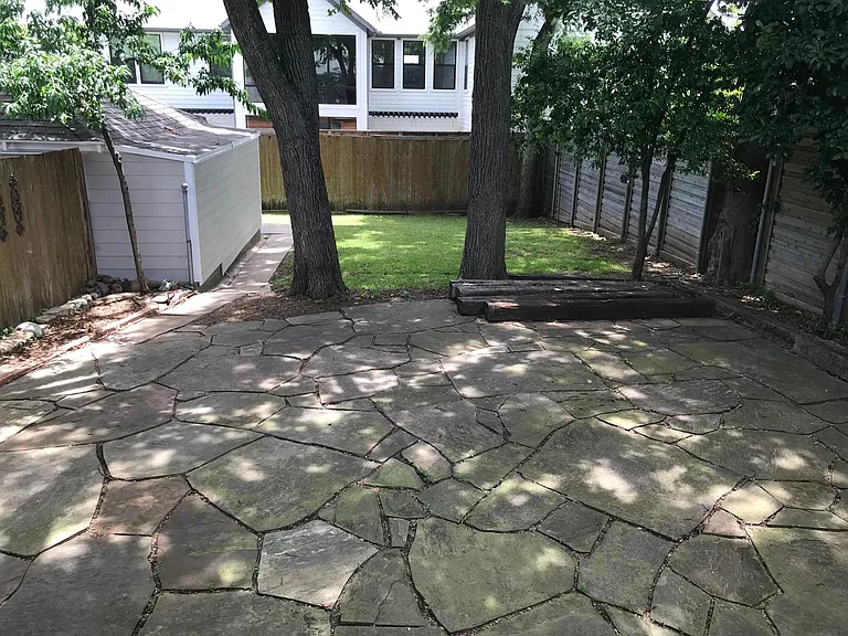 Large canopy of trees over flagstone patio.