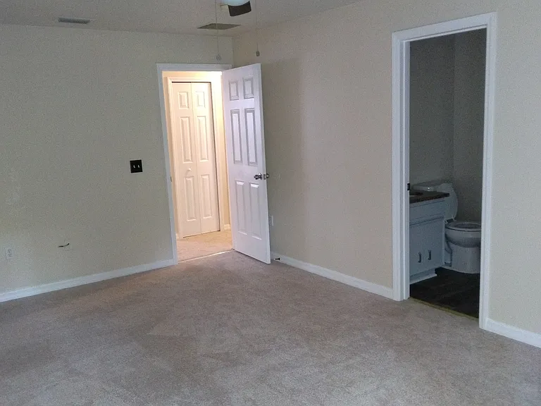 Large master bedroom with new ceiling fan installed.