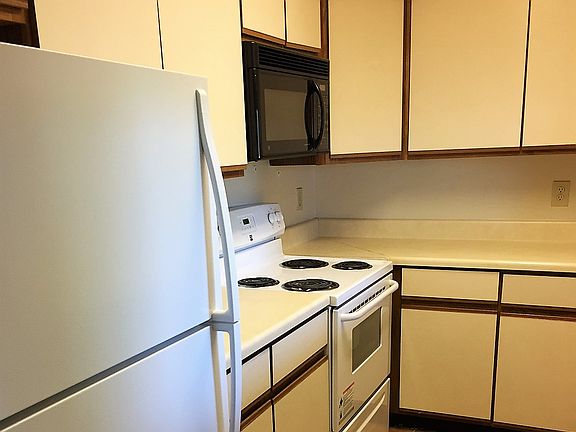 Galley style kitchen includes tile floors, a refrigerator, s