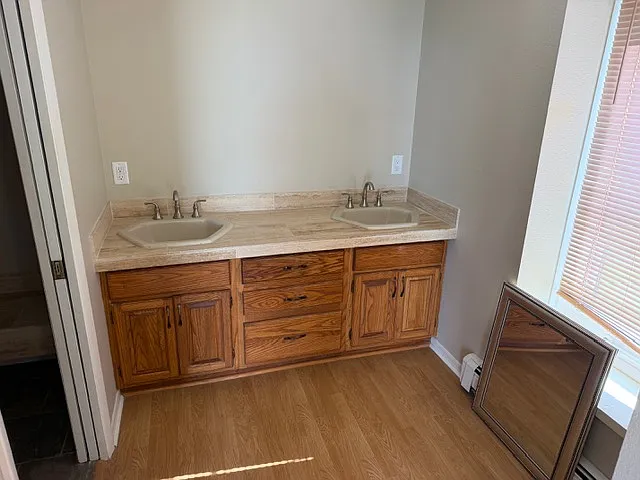 Primary ensuite bathroom. Double sinks outside toilet and shower area.