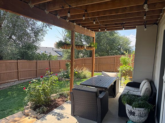 Well landscaped backyard oasis with covered patio and 6-foot privacy fences.