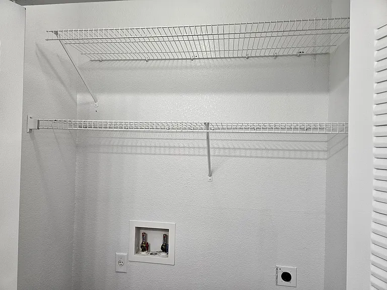 Convenient bathroom closet with built-in laundry hookups_perfect for a washer and dryer setup, offering added functionality without sacrificing space.