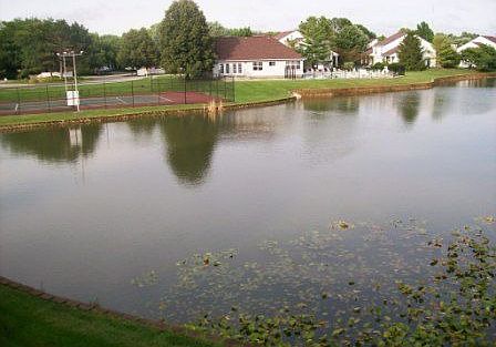 View of pond, clubhouse, and tennis courts from upper deck