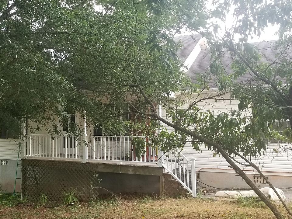 Mature trees provide shade to the front porch