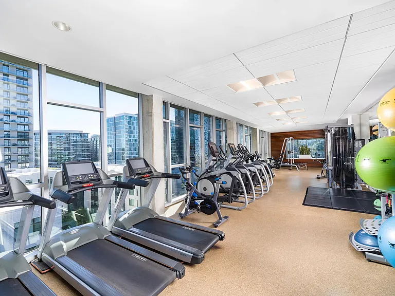 A cardio-focused fitness center at Modera Pearl with expansive windows, city views, and space designed for focused movement and everyday training.