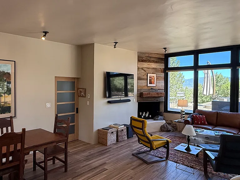 Living room wide view including full height windows to back deck and mountains