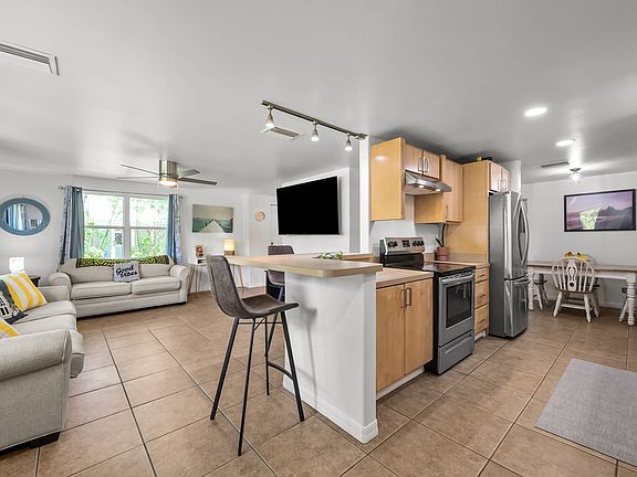 The kitchen seamlessly connects to the living room with a welcoming breakfast bar.
