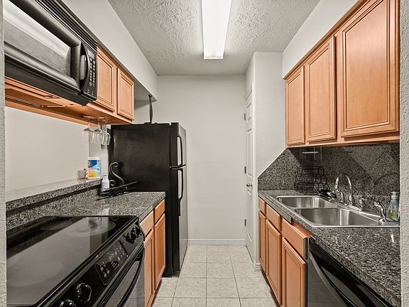Kitchen view with double sinks and dishwasher.