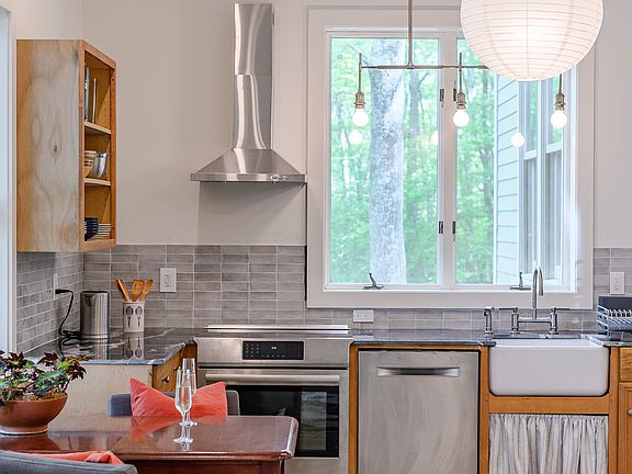 Full kitchen with farmhouse sink, Bosch appliances, microwave, dining nook.