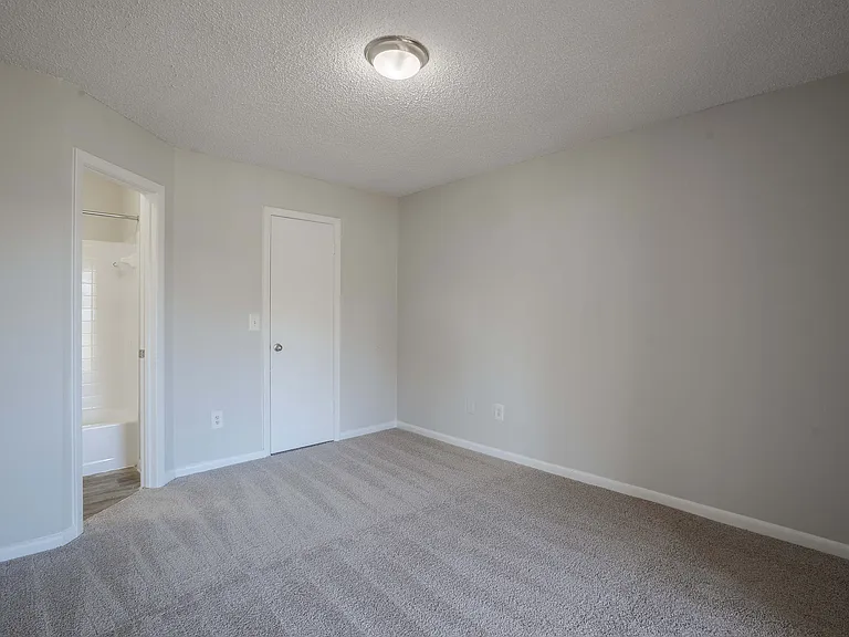 Step into comfort in this spacious and serene bedroom, complete with an inviting bathroom entrance.