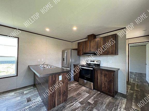 The kitchen is equipped with an electric range, a refrigerator, and a dishwasher.