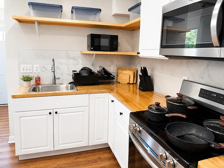 Well-equipped kitchen with ample counter space, open shelving, and a full appliance set for everyday cooking.