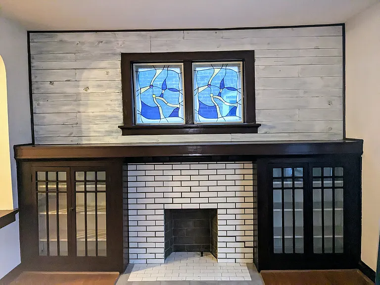 Beautiful stained glass windows and custom, built-in cabinets surround the fireplace (non-functioning).