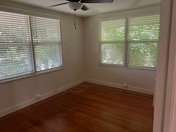 Front bedroom with blinds on windows, ceiling fan and closet.