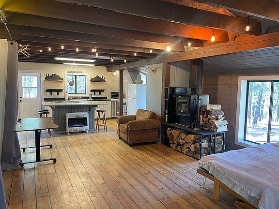 Open layout showing kitchen, fireplace, propane heater, desk, futon/bed. (furnishings optional)