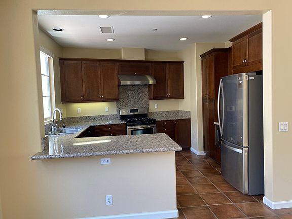 Kitchen with updated stainless steel appliances. Big window by the sink.