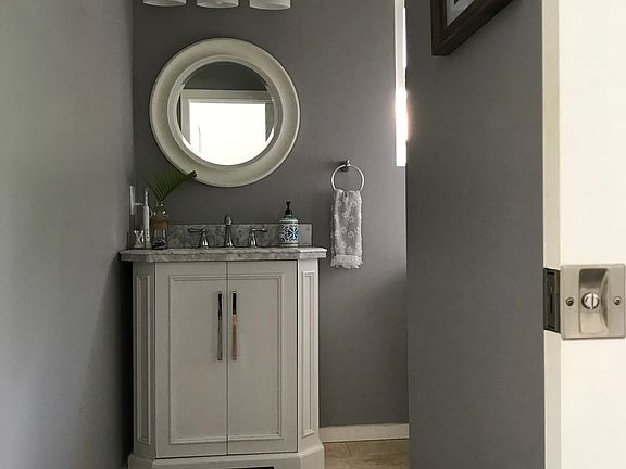 Attractive full bathroom with travertine floors and travertine shower stall.