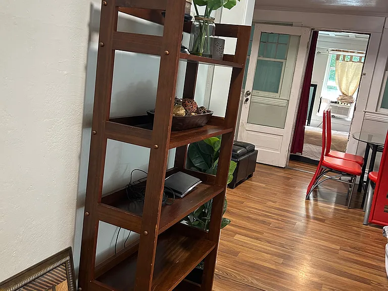 Open common area with durable wood-look flooring, shelving for extra storage, and an easy flow to adjacent rooms.