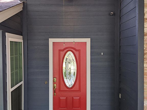 Front porch includes space for a few chairs and a bench for outdoor seating.