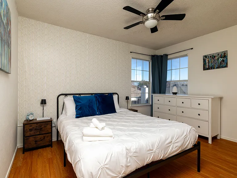Stylish second bedroom with a queen bed and modern industrial touches.