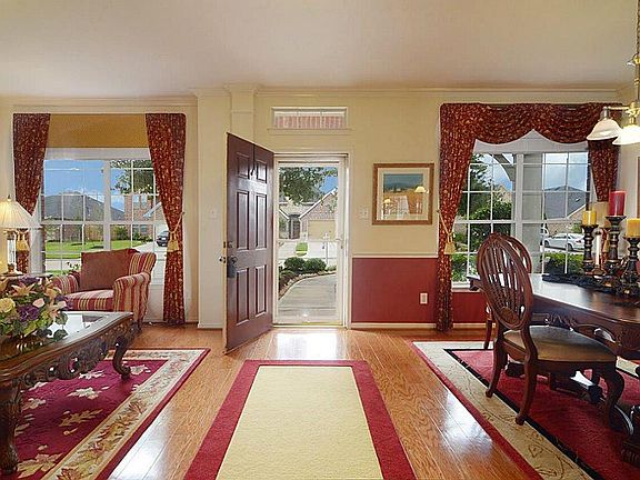 This view is looking towards the Front Door and captures the Dining Room and Living Room