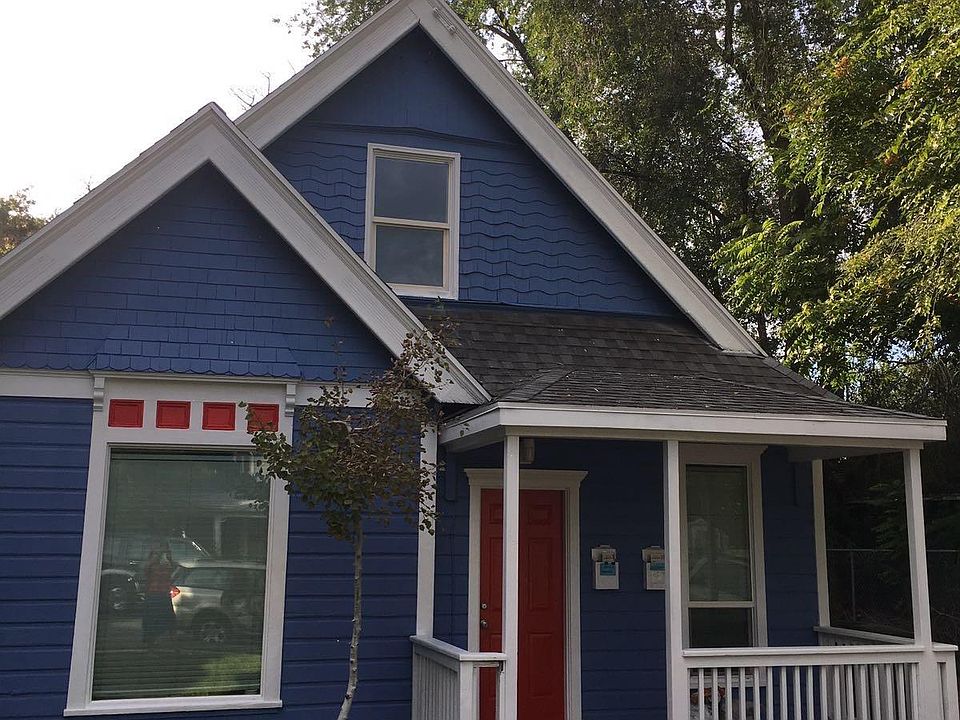 The second-floor apartment for rent is located on the right side of the house, through the white fence and private gate/entrance.