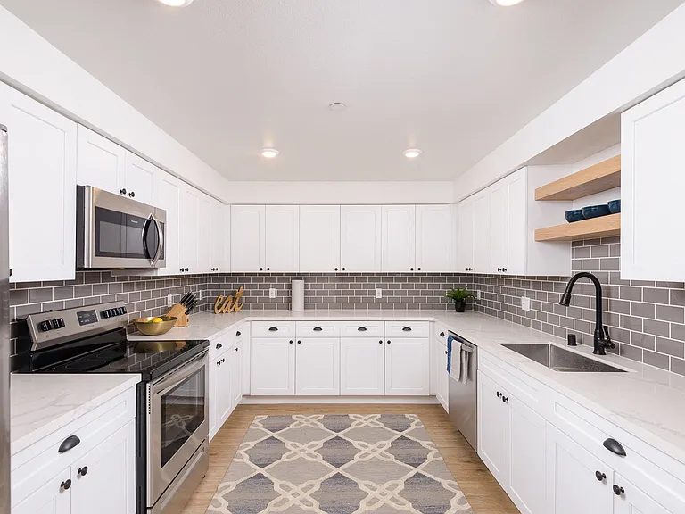 Fully-equipped kitchens with white shaker cabinetry and oil-rubbed bronze hardware package