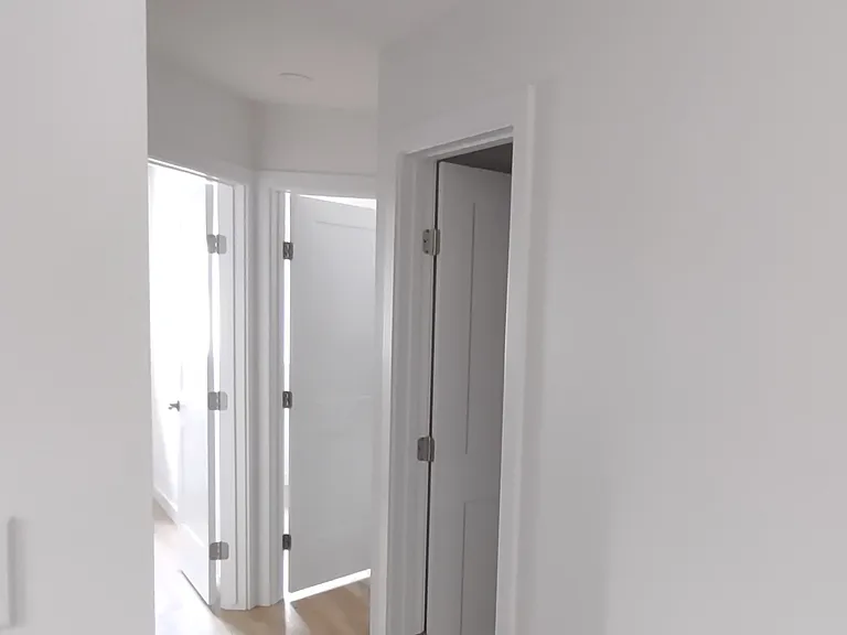 Hallway with shared bathroom entrance.
Other two bedroom units