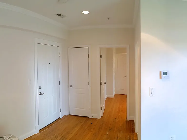 Door to the entrance of Unit, Coat Closet, and Bedroom