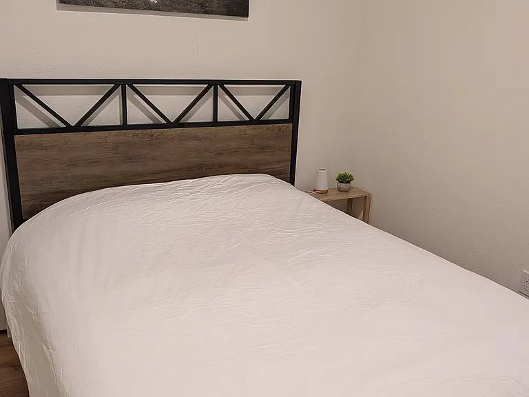 One of two bedrooms with queen bed, adjustable desk, and ample closet.