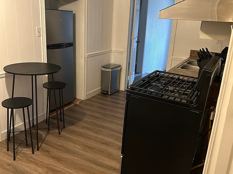 KITCHEN WITH HIGH TOP FOR TWO, REFRIGERATOR, GAS STOVE.