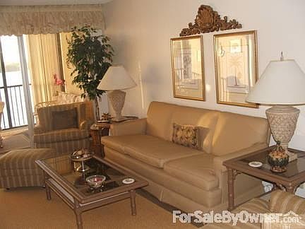 Open area from kitchen to lanai
						:
						Leather couch in setting of laminate wood floor with neat area rugs, nr lanai