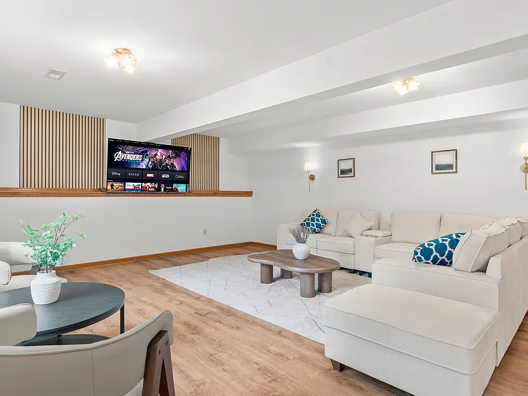 Spacious basement recreation lounge with generous seating and plenty of open space for relaxing, entertaining, or gathering with family and friends.