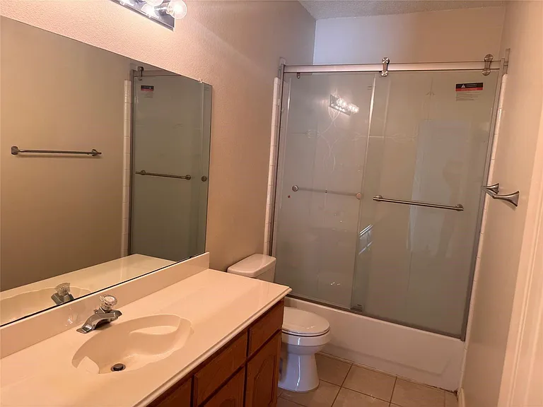 Bathroom vanity with an integrated sink and chrome faucet, set against a large mirror