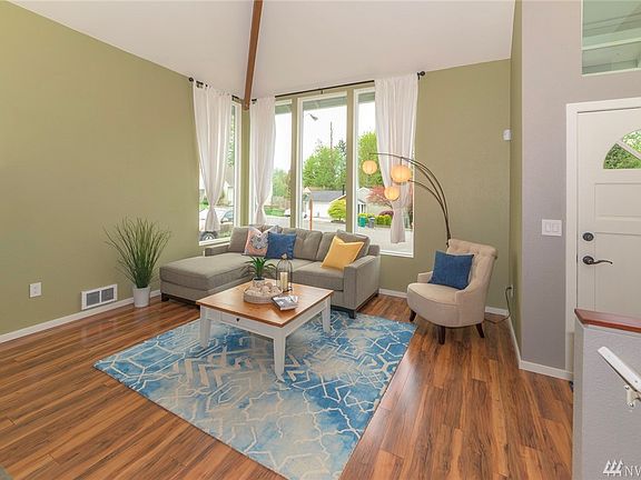 Lovely living room with wonderful light and vaulted ceilings. Exposed beam, new doors and floors add interesting architectural detail.