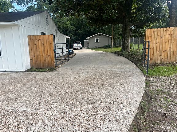 The concrete driveway goes all the way to the back fence. Plenty of space for parking and a double gate. The detached apartment/in-law suite in rear.