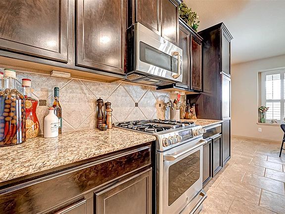 6 gas burner stove, stainless steel appliances, custom backslash and beautifully maintained granite counter tops.