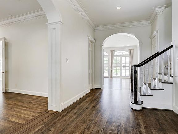Hardwood floors start in the entry and flow throughout the main level, with exception of beautiful stone floors in the kitchen area. To the right is the formal dining. To the left is the formal living, wet bar, and study.