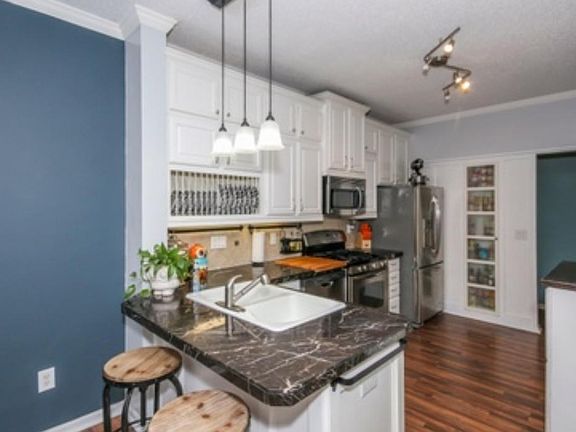 Beautiful counter tops with white cabinets show off updated kitchen.