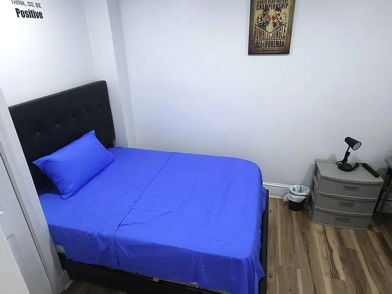 Private bedroom with a full bed, nightstand, and dedicated desk area, plus hardwood-style flooring for easy upkeep.