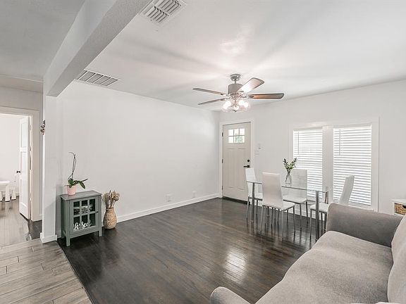 Living room with dark wood-type flooring and ceiling fan