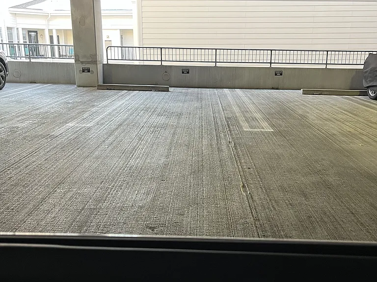 Unit's reserved parking space just steps to short hallway to enter unit