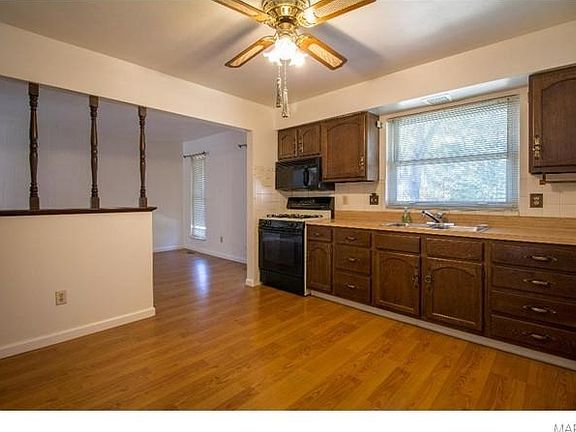 Kitchen that flows into dining room with new laminate hardwood flooring.