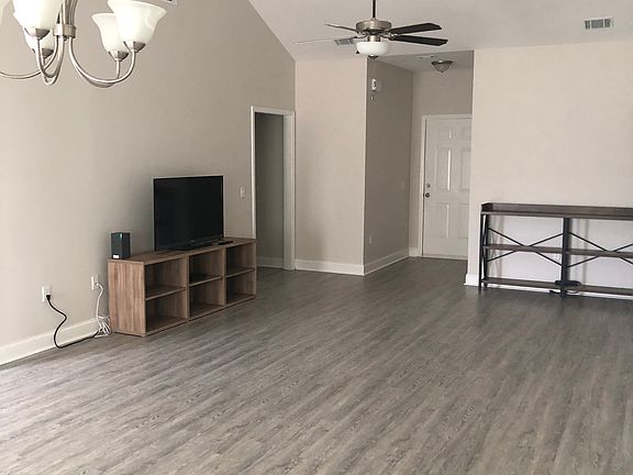 view of front door exit and Livingroom area with left entrance to the other 
 2 bedrooms